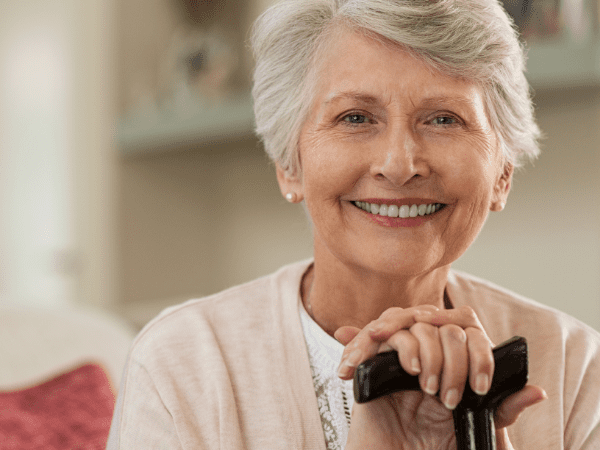 Mujer mayor, de pelo blanco y sonriente, representando la salud por avances científicos como el Proyecto Prometeo de DIMECAR